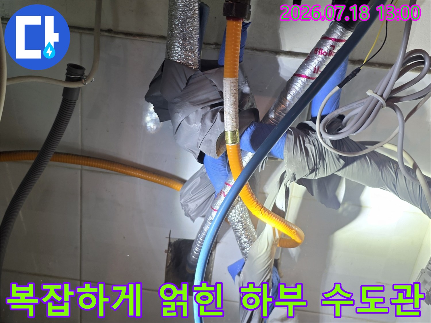 파란색 호스와 노란색 관 그리고 은색 보온재가 함께 있는 주방 배관-근접사진