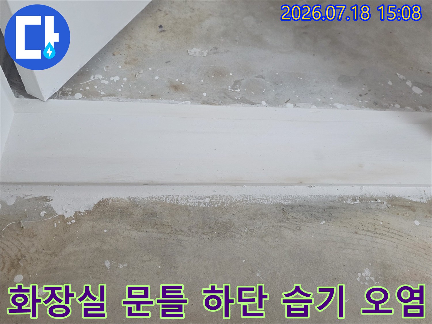 하얀-마감재의-문턱-아래쪽으로-습기가-스며들어-발생한-얼룩과-변색된-바닥