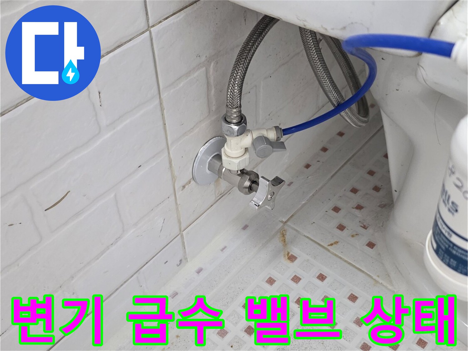 벽면 타일과 연결된 수도 밸브 및 급수 호스 근접 사진