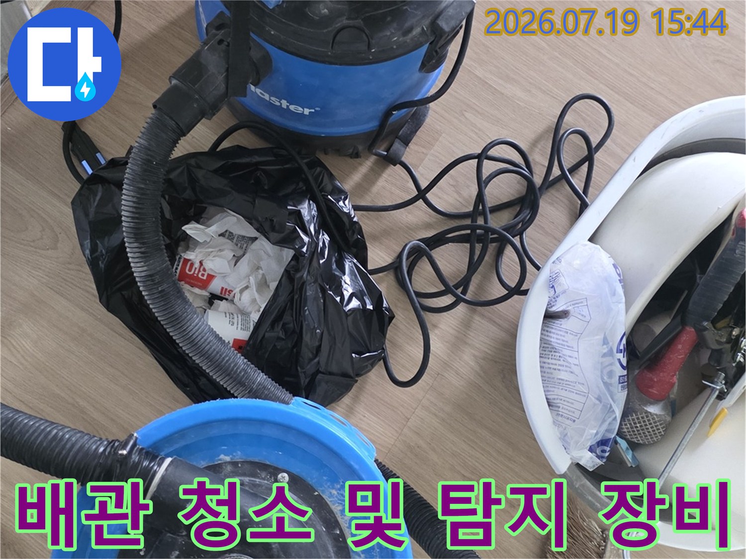 파란색 강력 흡입기-배관 호스-작업 도구가 정돈된 누수 공사 현장 모습