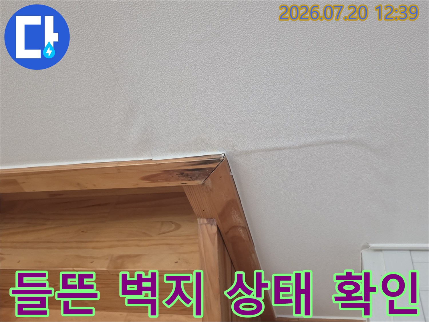 나무 선반 상단부의 벽지가 수분을 흡수하여 굴곡이 생긴 모습