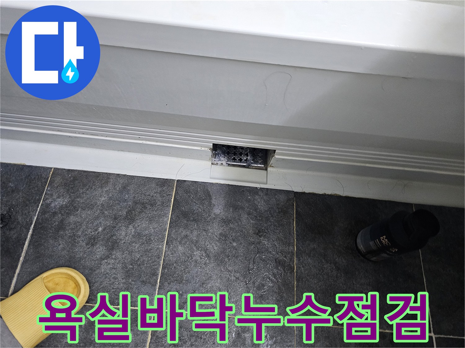 어두운 회색 타일과 배수구 주변의 마감 상태