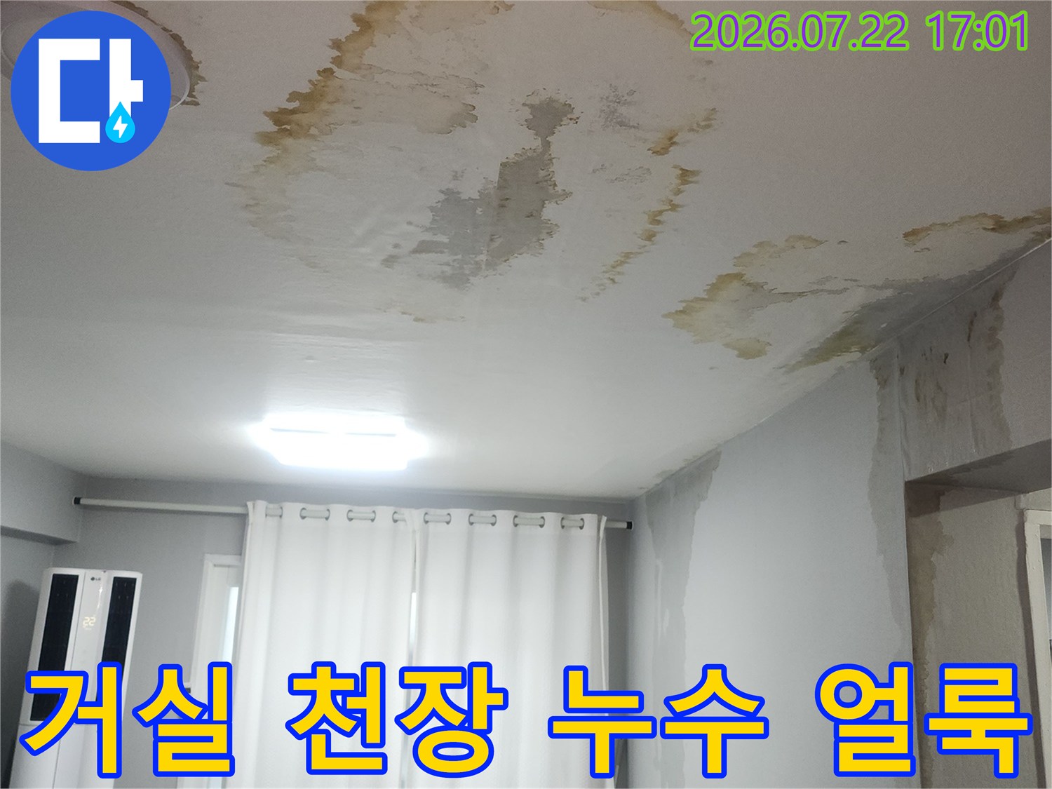 거실 천장에 발생한 노란색 누수 흔적과 젖은 벽지 상태