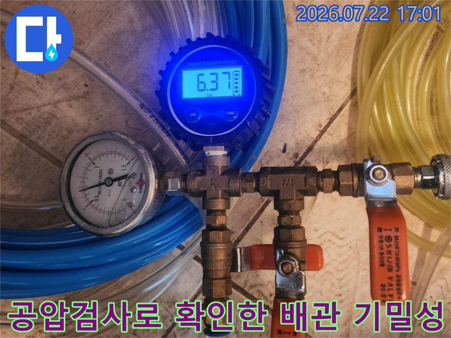 노란색과 파란색 호스가 연결된 배관 시스템과 공압 측정 게이지