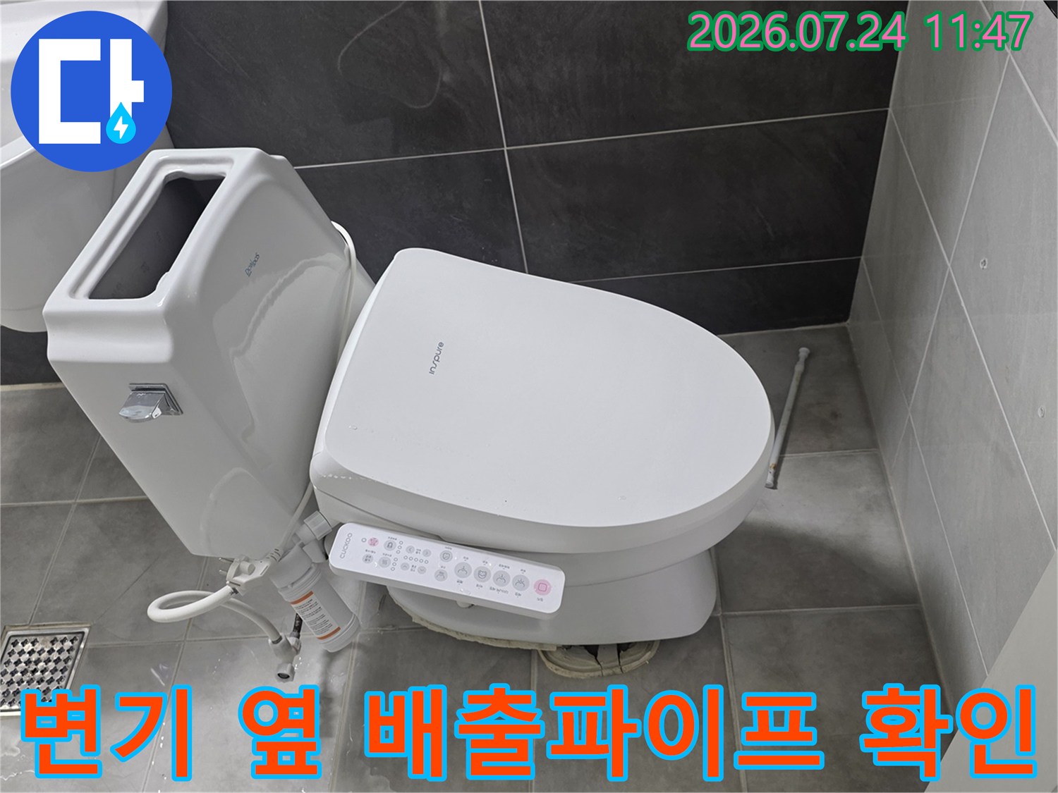 세면대와 변기 사이에 위치한 노출형 하수 파이프라인 점검