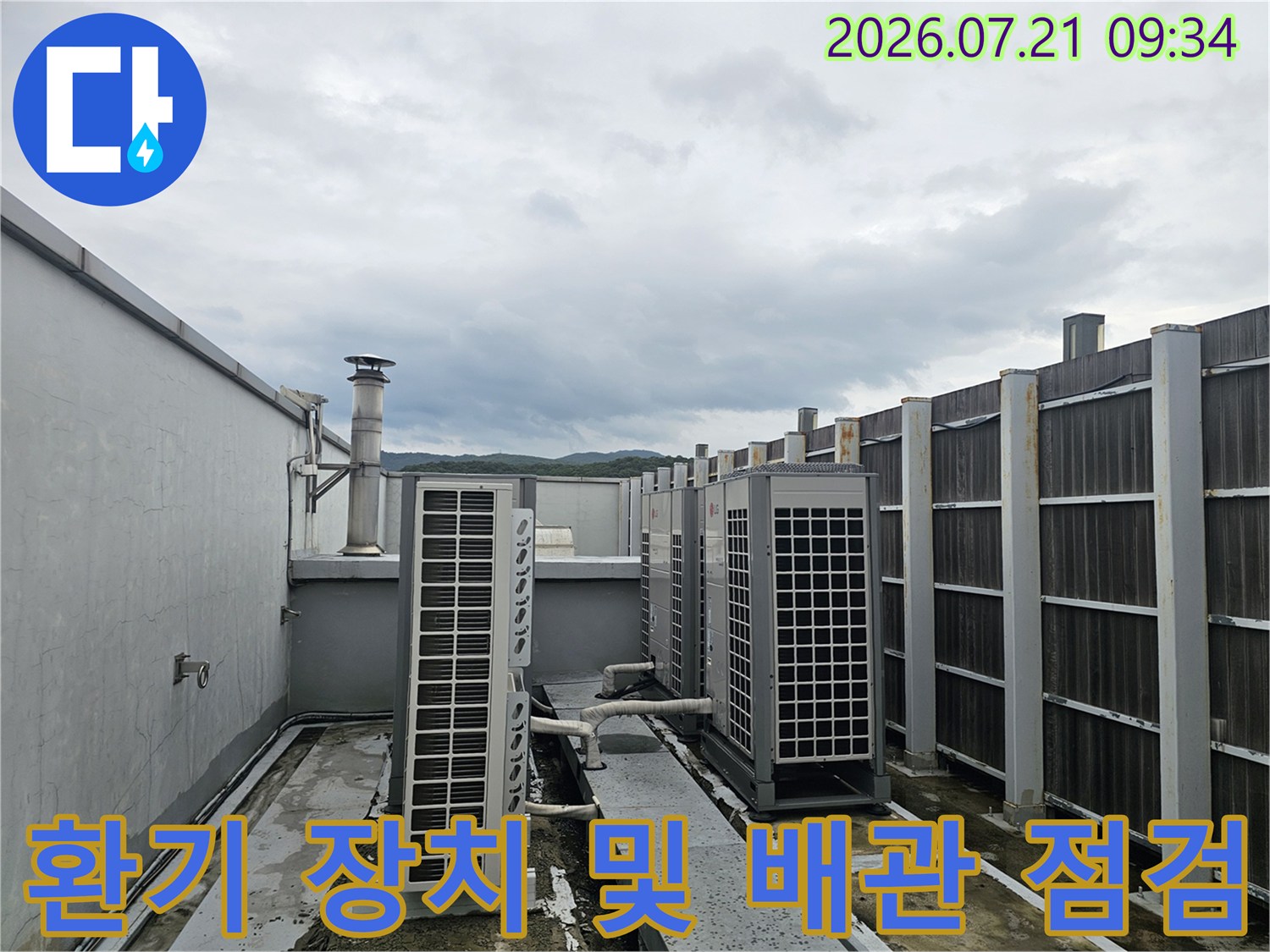 옥상에 배치된 대형 팬과 연결된 복잡한 배관망을 조사하는 모습