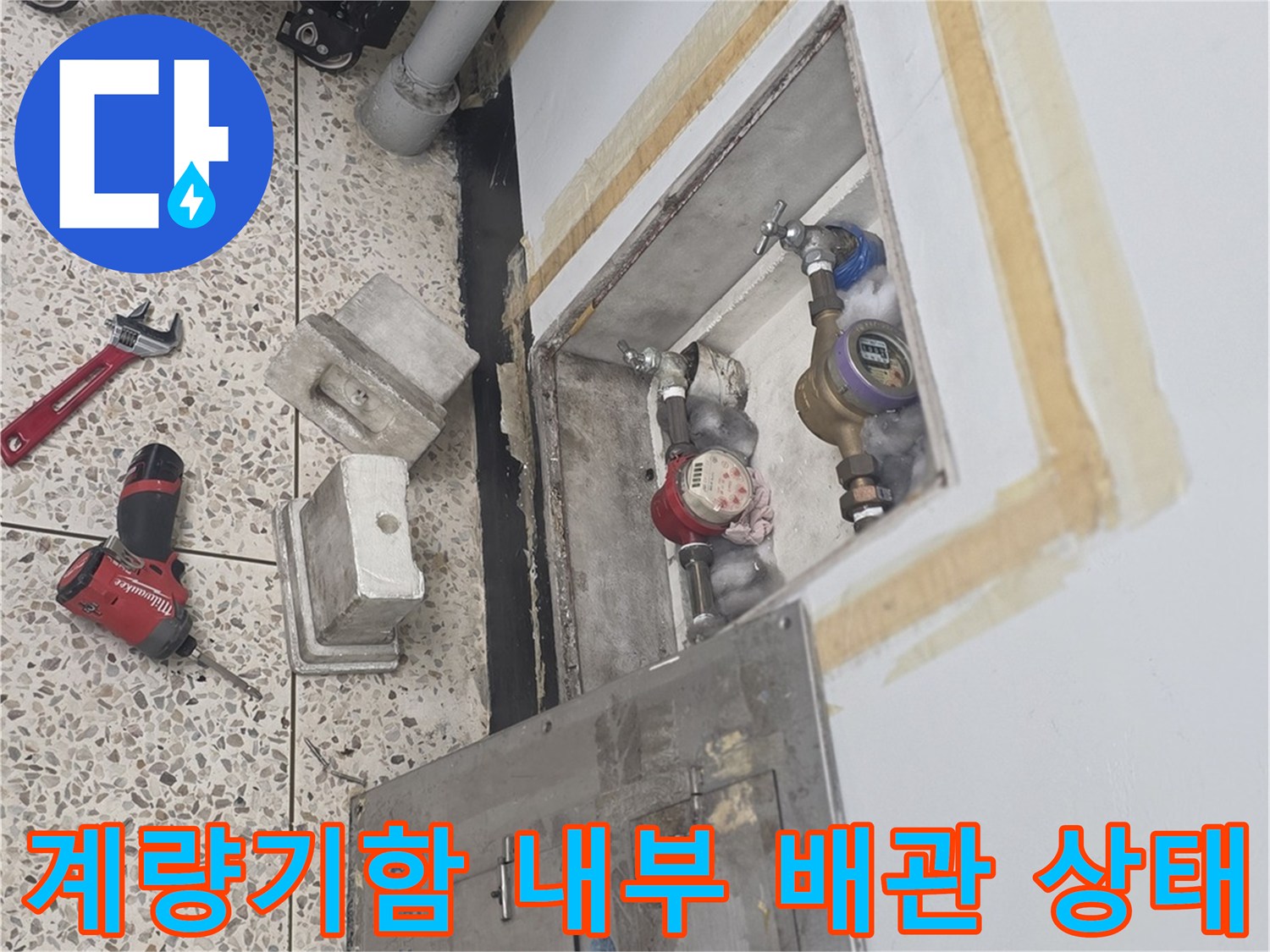 수도 계량기 함 내부에 노출된 배관과 점검 도구들