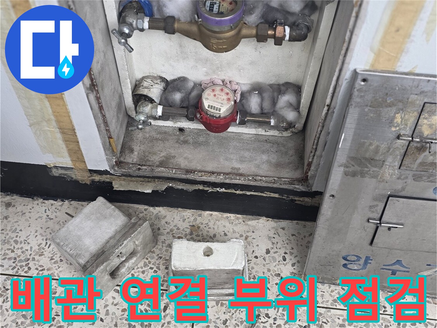 수도 계량기와 밸브가 노출된 배관 함 내부 사진