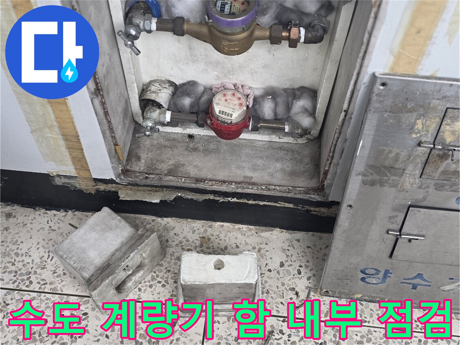 수도 계량기함 내부의 배관과 장비 상태를 확인하는 모습입니다.