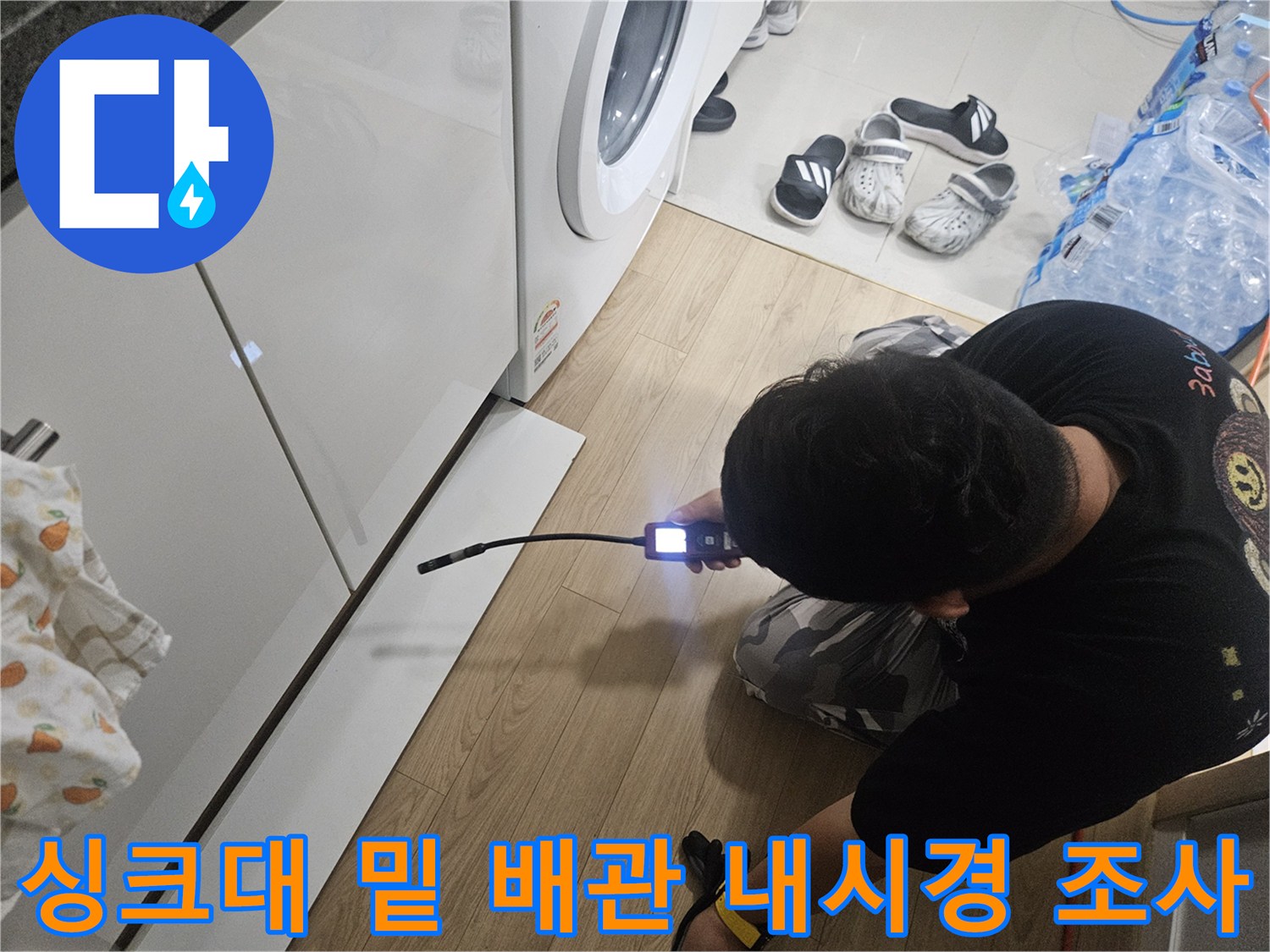 내시경 카메라의 빛으로 싱크대 아래 배관 주변을 정밀하게 살피고 있습니다.