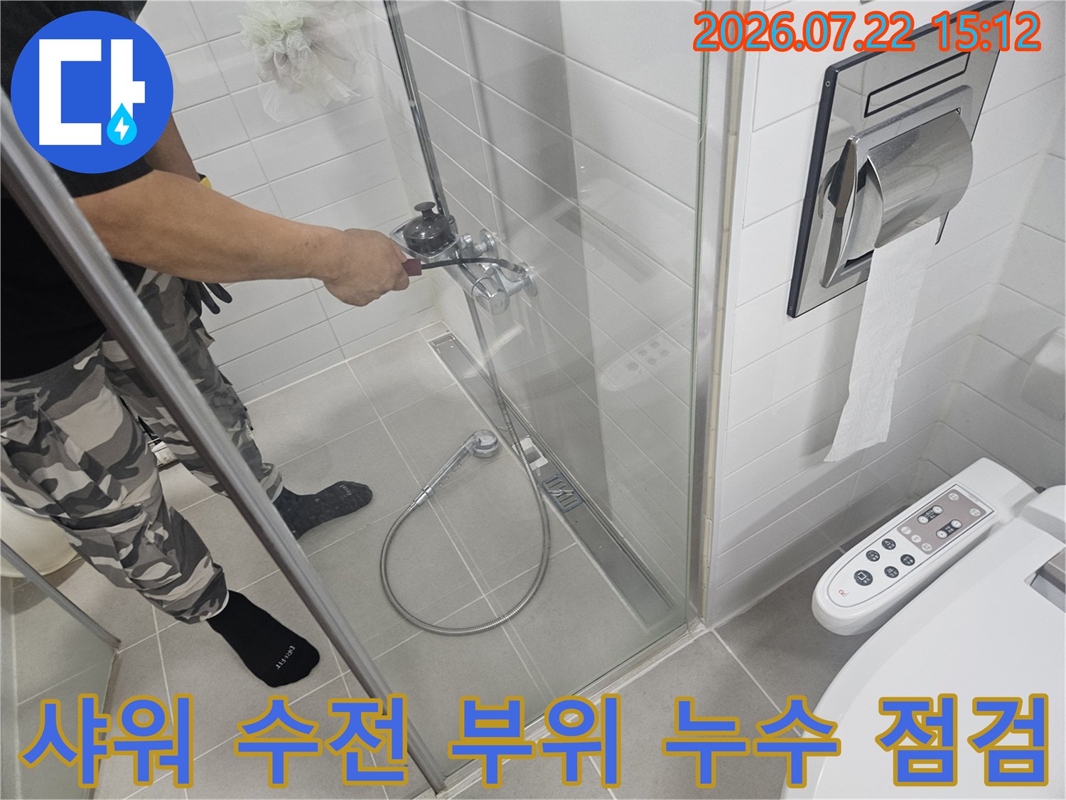 엔지니어가 욕실 내-금속 재질의 샤워기 수전 밸브를 세밀하게 확인하고 있는 장면