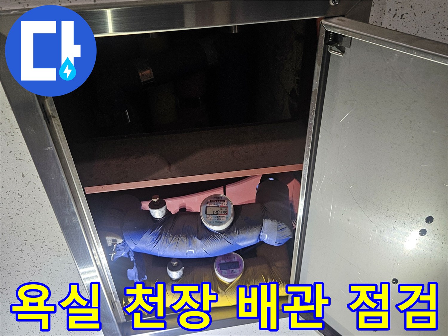 점검구 내부의 파란색-노란색 배관과 연결 부위 모습