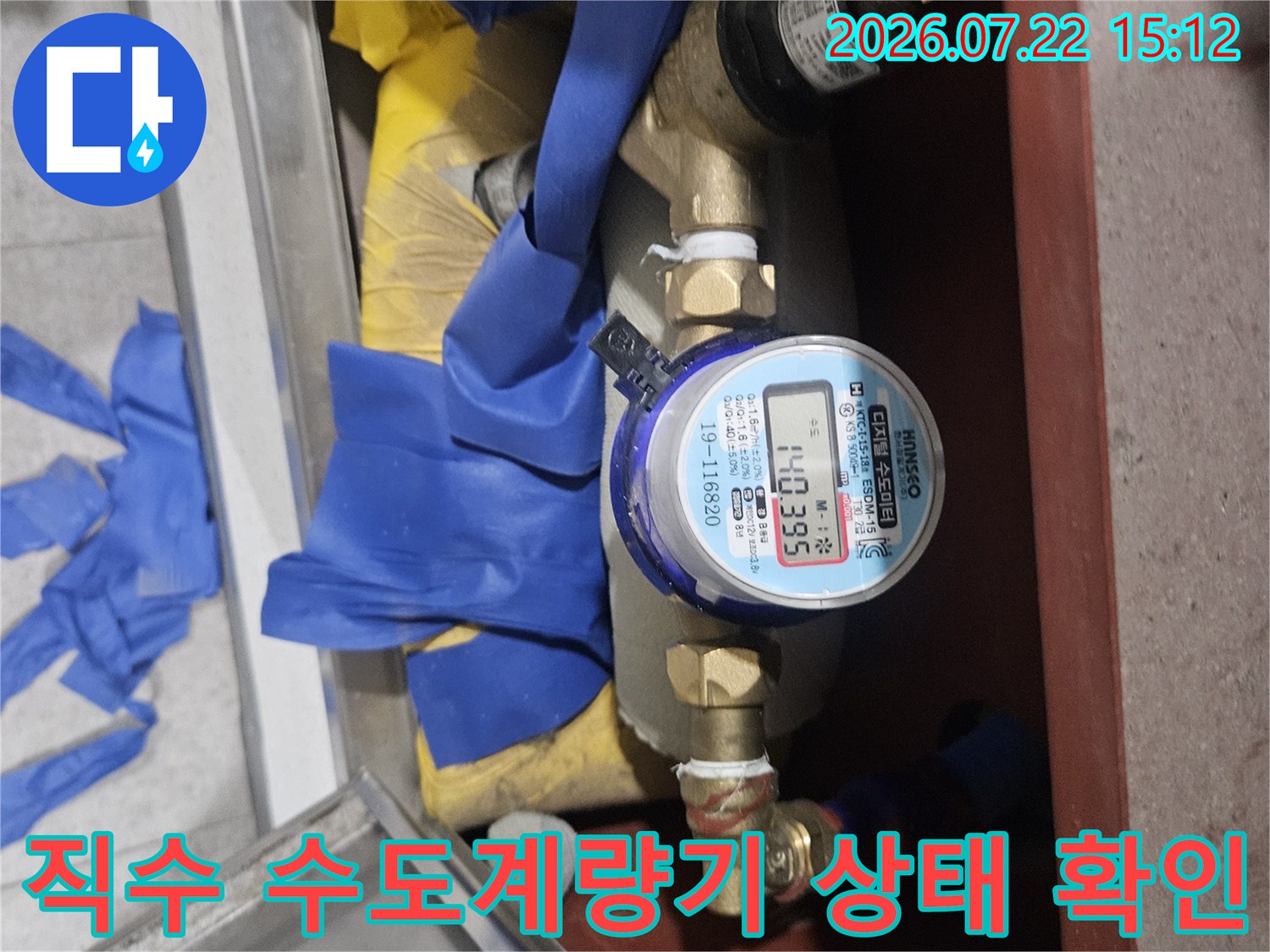 파란색 보호 테이프가 감겨 있는 직수 수도계량기와 연결 배관 모습