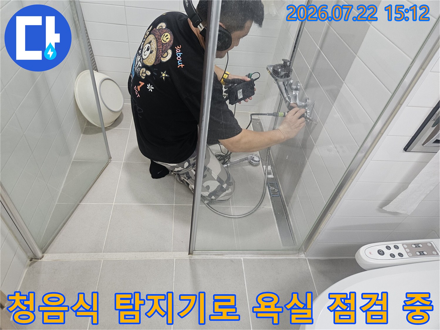 화장실-내부에서-전문-엔지니어가-헤드셋을-착용하고-청음-탐지기를-사용해-배관-누수-지점을-찾고-있는-모습