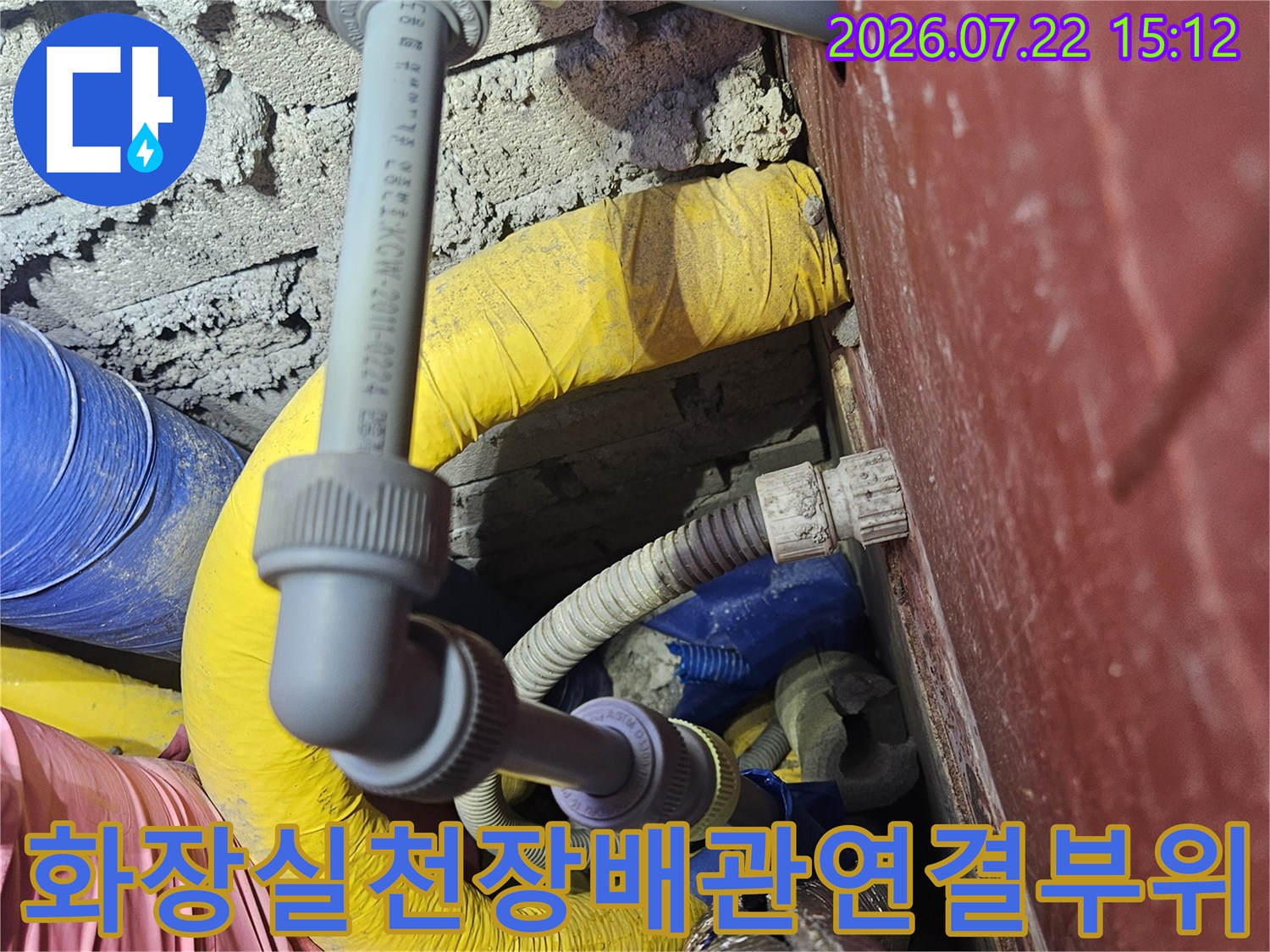 화장실-천장-내부에-복잡하게-얽혀있는-회색-배관과-노란색-보온재-모습