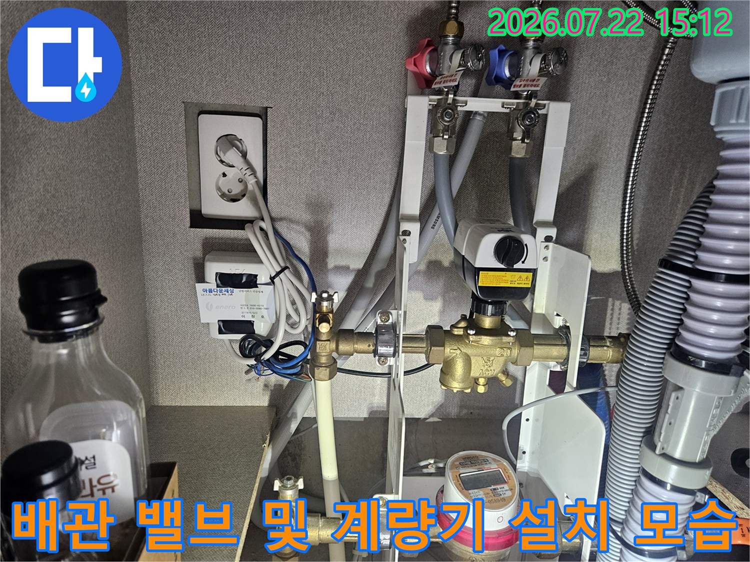 흰색 벽면 앞에 설치된 복잡한 수도 배관과 밸브-계량기 장치