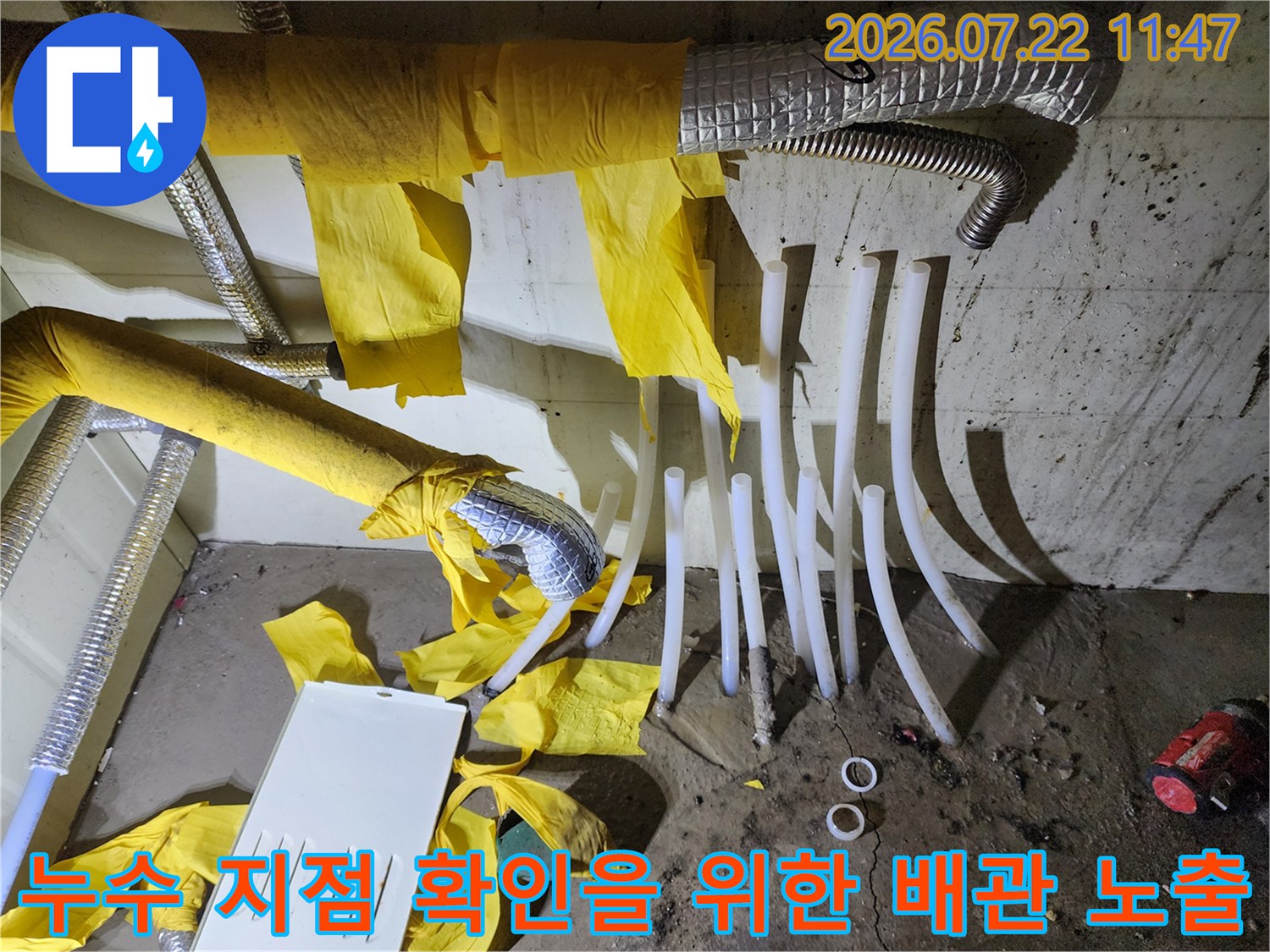 보일러 하단에서 분배기로 이어지는 흰색 PEX 배관들이 보온재 없이 드러난 모습-누수 점검 중