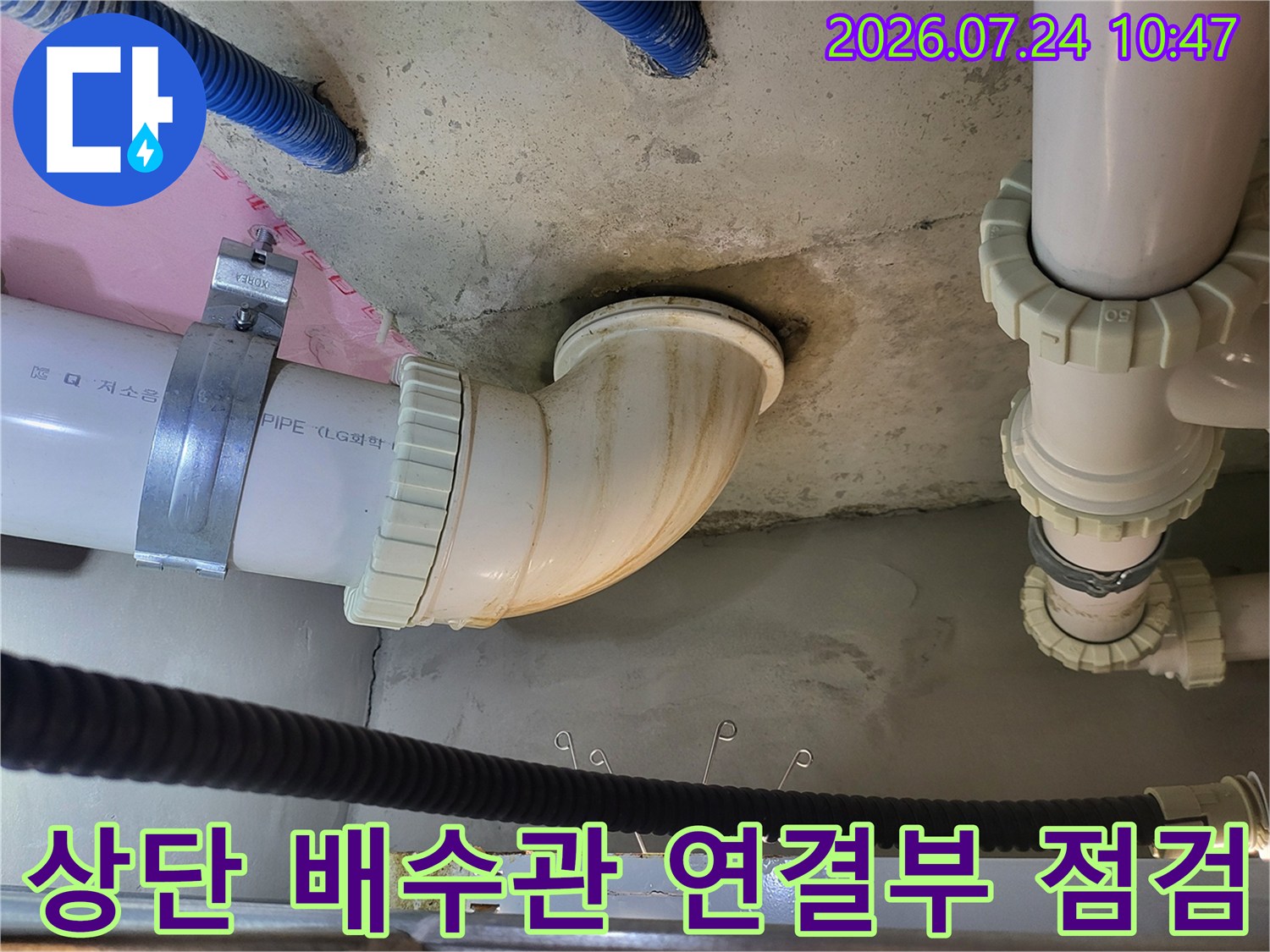 천장 내부 배수 파이프의 굴곡진 구간과 연결 부위를 세밀하게 검사하는 모습