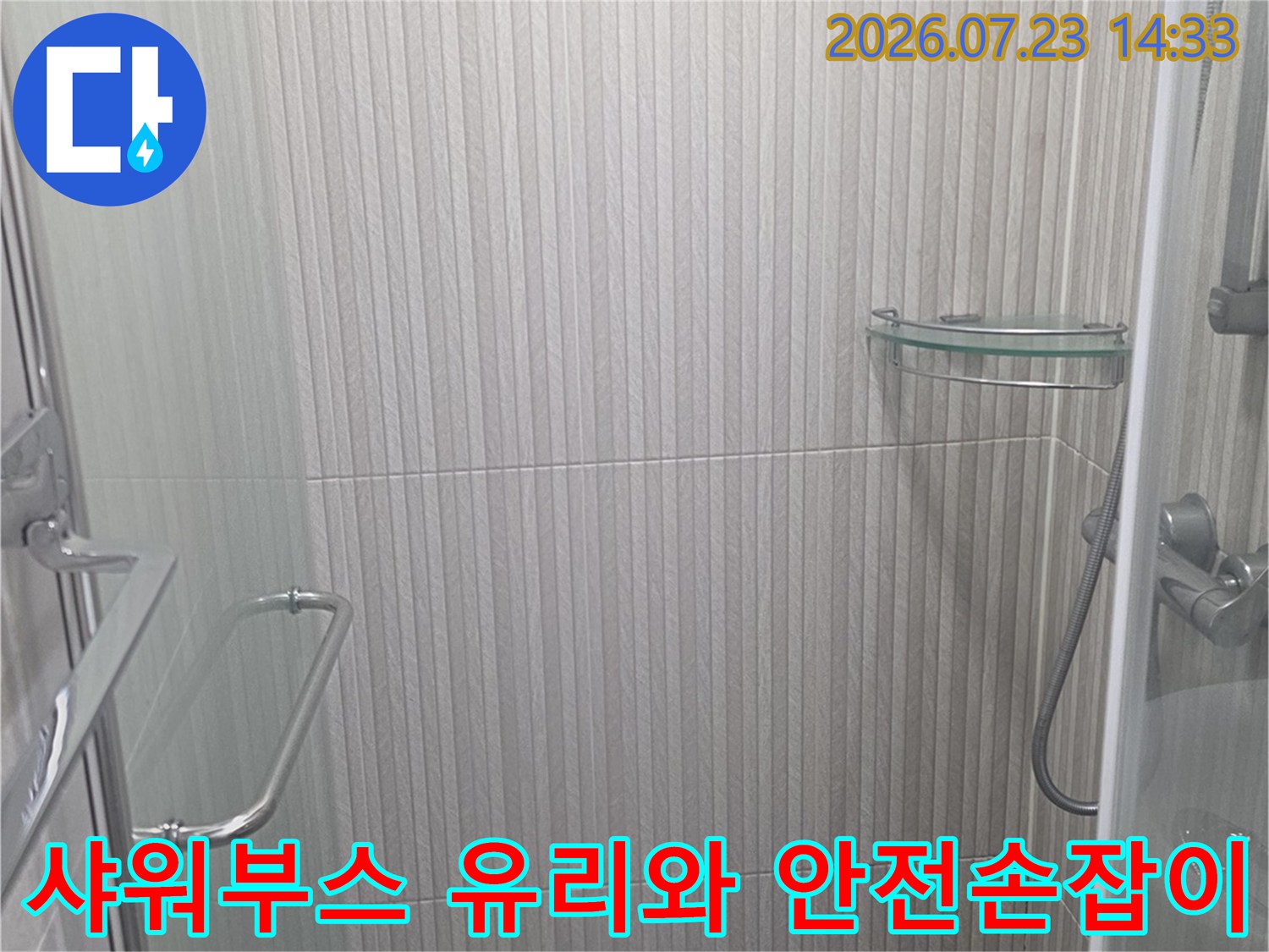 투명 유리 파티션과 하단에 설치된 금속 재질의 안전 손잡이가 보이는 욕실