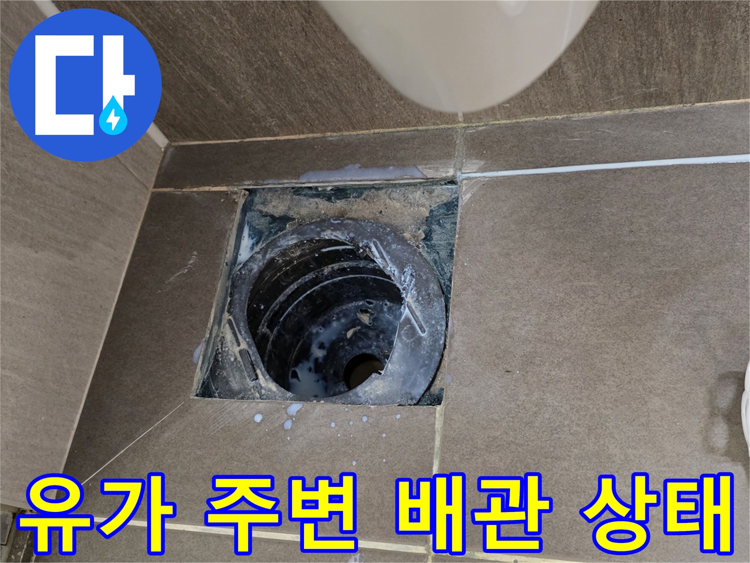파손된 타일 사이로 드러난 욕실 배수관 및 오염된 부위