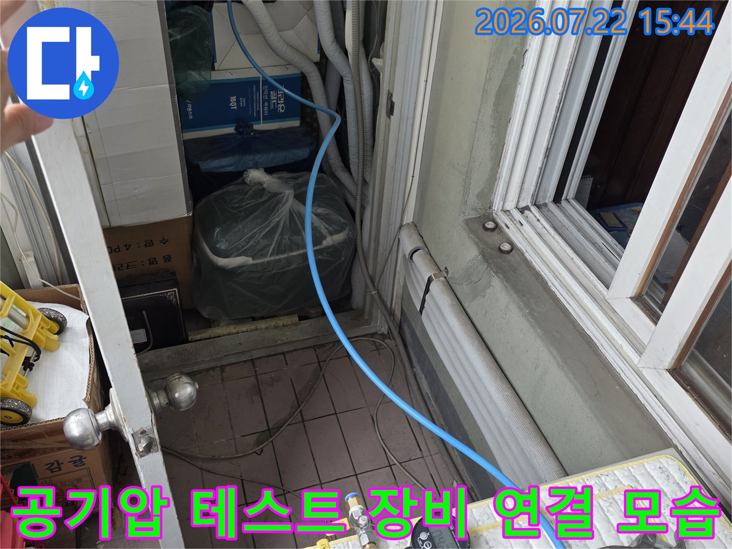파란색 고무 호스가 배관에 연결되어 압력 게이지로 이어지는 정밀 진단 사진