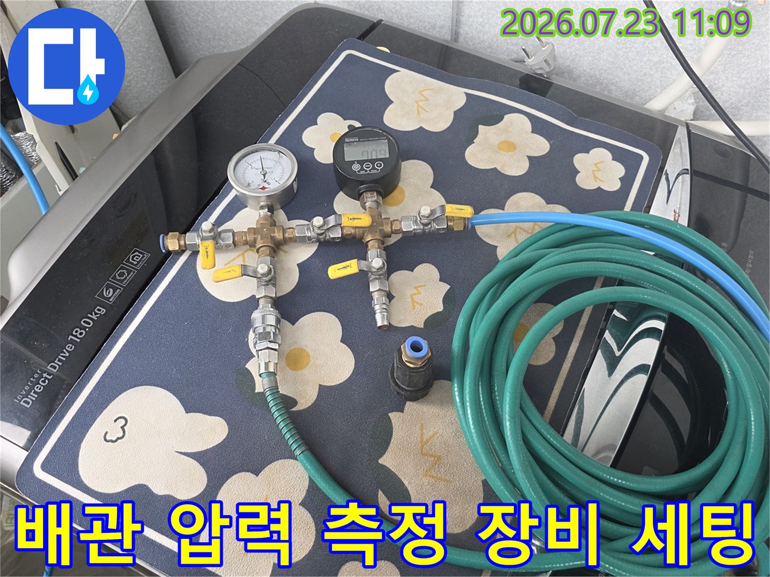 보일러 배관에 연결된 아날로그 압력계와 디지털 계측기-초록색 호스 연결 상태