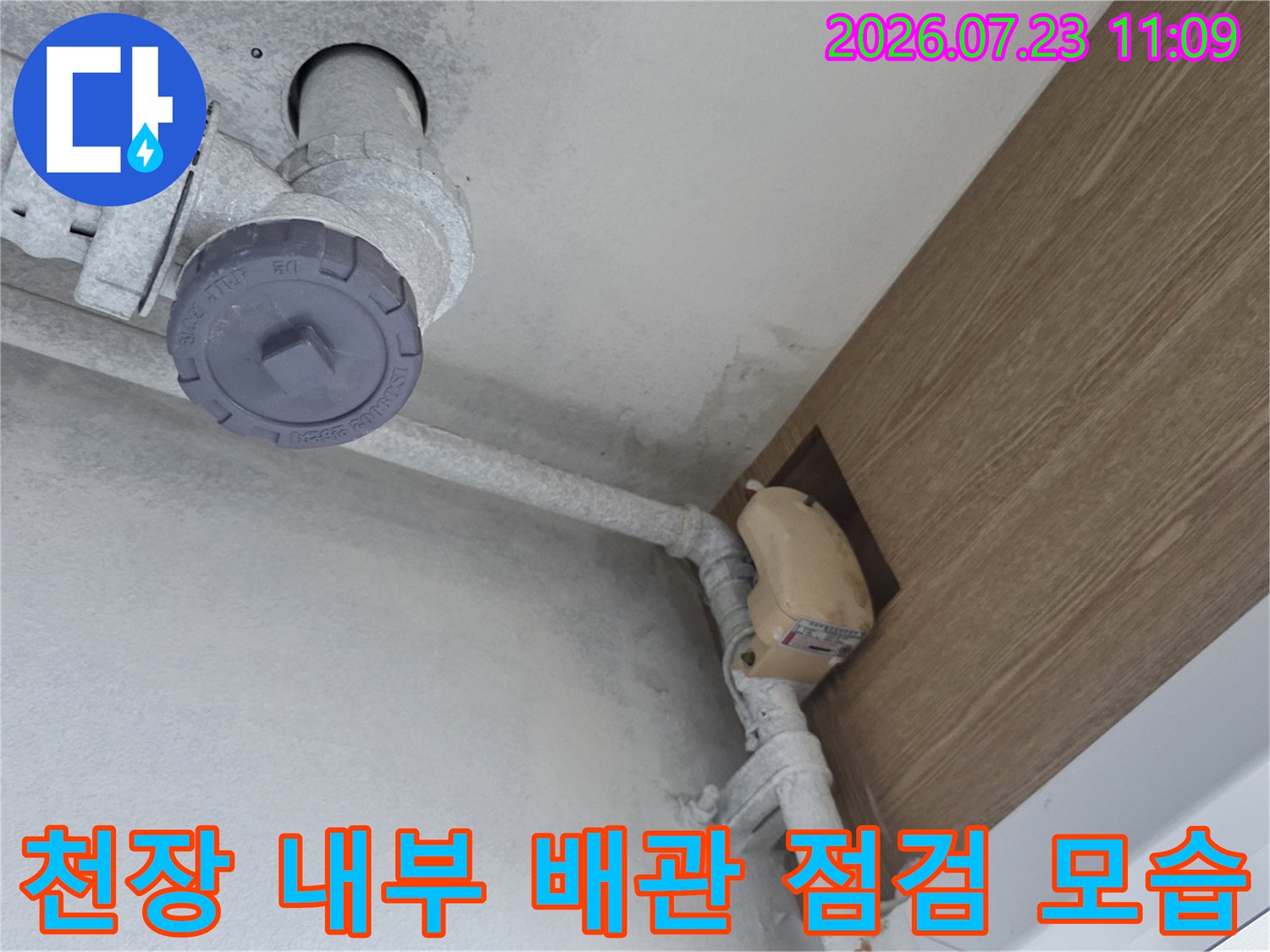 천장 속에 설치된 회색-PVC 배관과 연결 부속들의 상세 사진