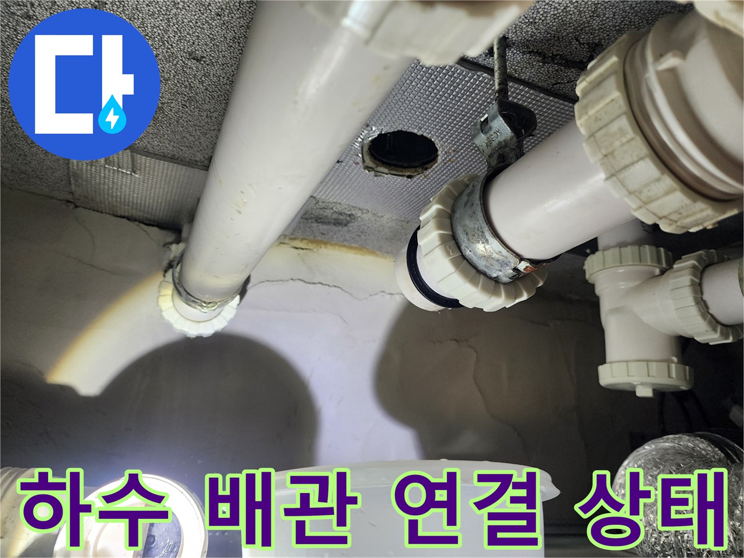 천장에 설치된 흰색 하수 배관과 분기되는 지점의 점검 모습입니다.