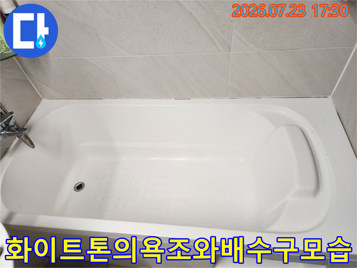 하얀색 욕조 내부의 배수구-홀과 주변 타일 마감 상태를 찍은 사진