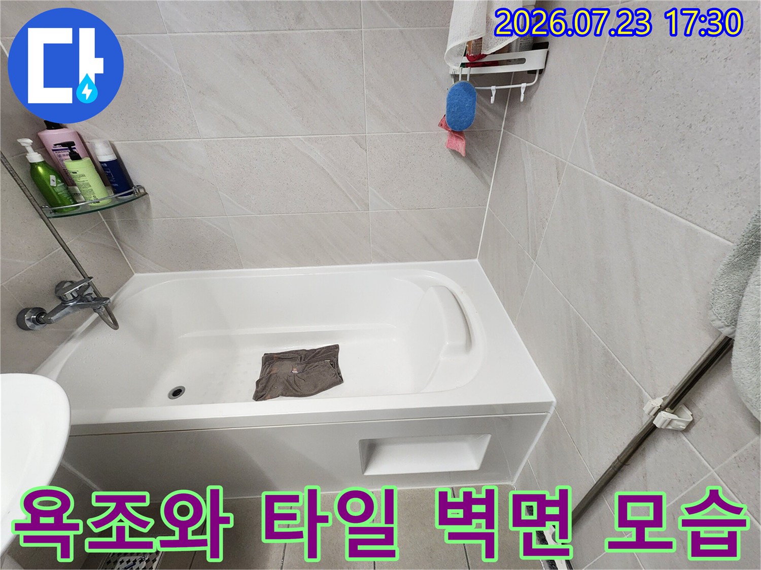 흰색 욕조가 설치된 욕실의-타일 벽면과 수전 모습