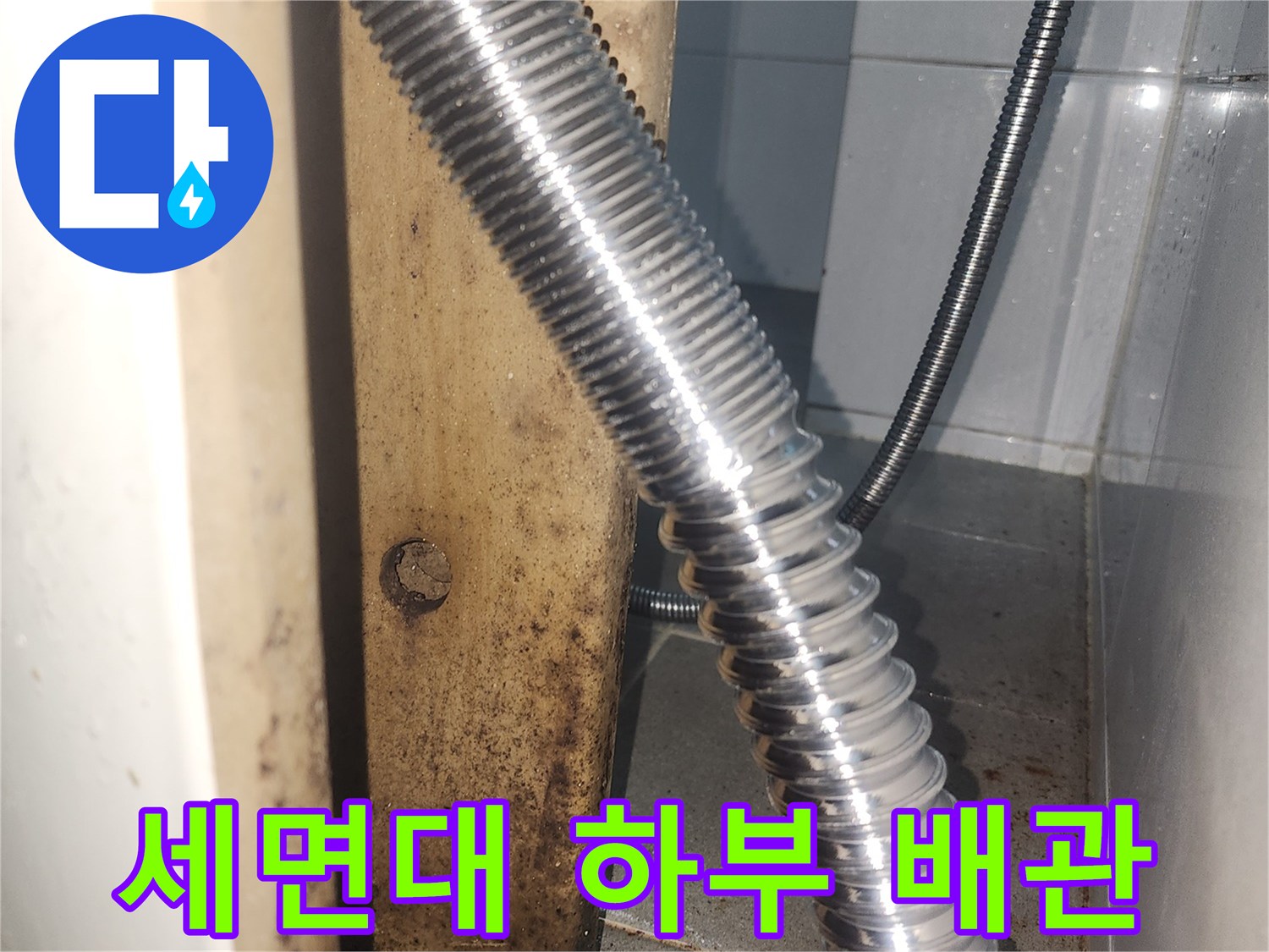 금속-자바라-배관-및-벽면-연결-부위-근접-사진
