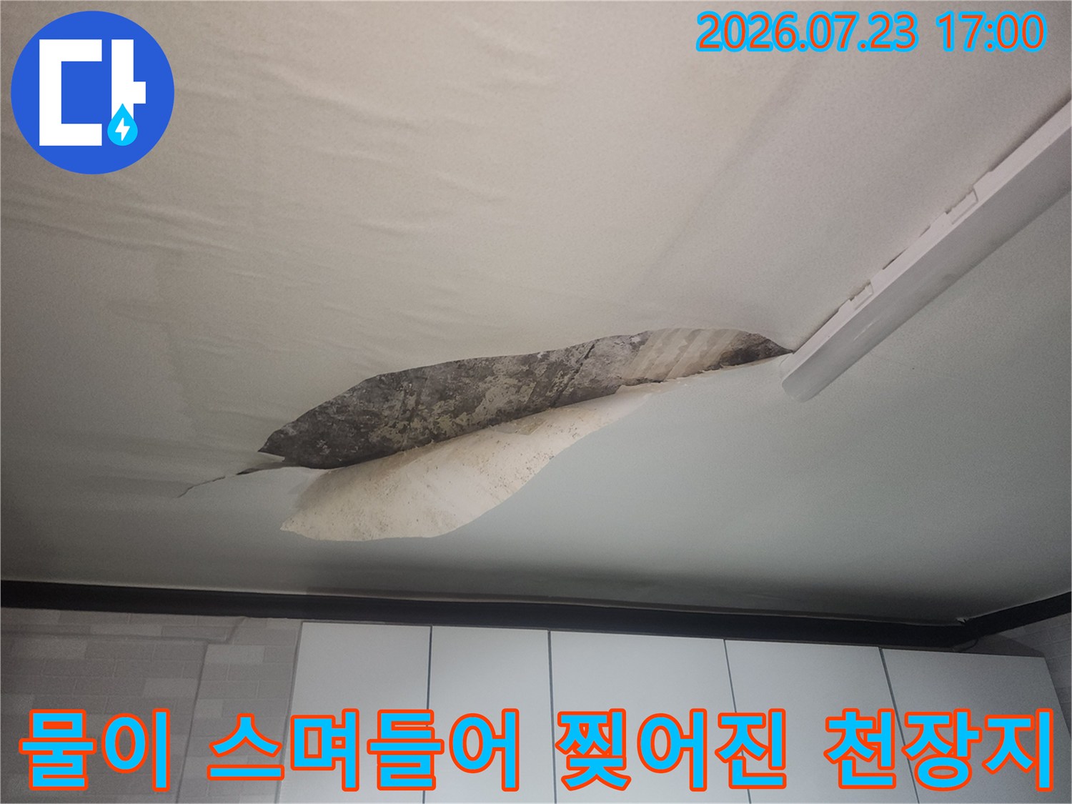 천장지가 물에 젖어 일부가 뜯겨나가고 내부 콘크리트 층이 드러난 모습