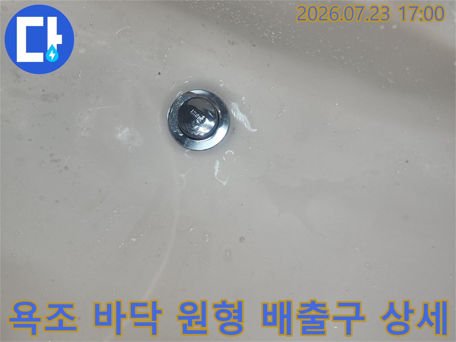 흰색 욕조 하단에 매립된 스테인리스 소재의 배수-배관 진입로 부분