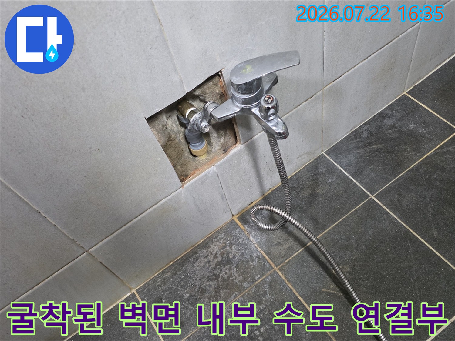 금속제 수전과 벽면 매립 배관의 연결 부위가 타일 제거 후 노출되어 있는 사진