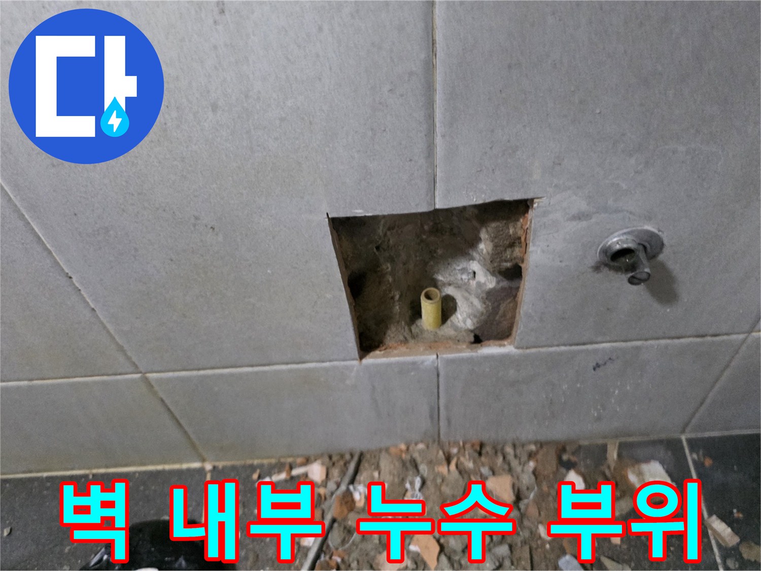 타일 굴착 공간 내부에 노출된 파손된 노란색 수도 배관