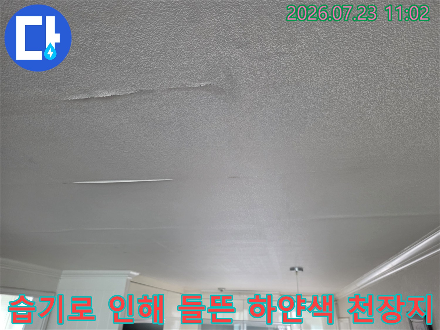 거실 천장의 흰색 마감재가 수분을 머금어 불룩하게 솟아오르고 갈라진 모습