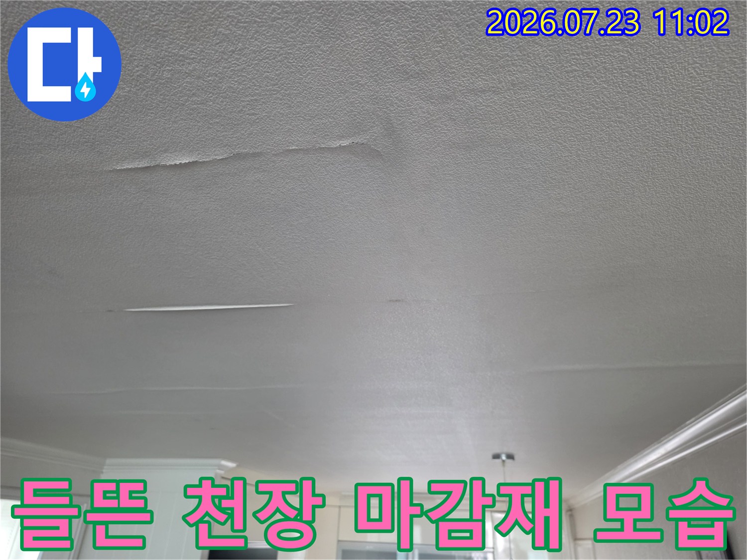 빗물 유입으로 인해 거실 천장의 흰색 마감재가 들뜨고 갈라진 상태