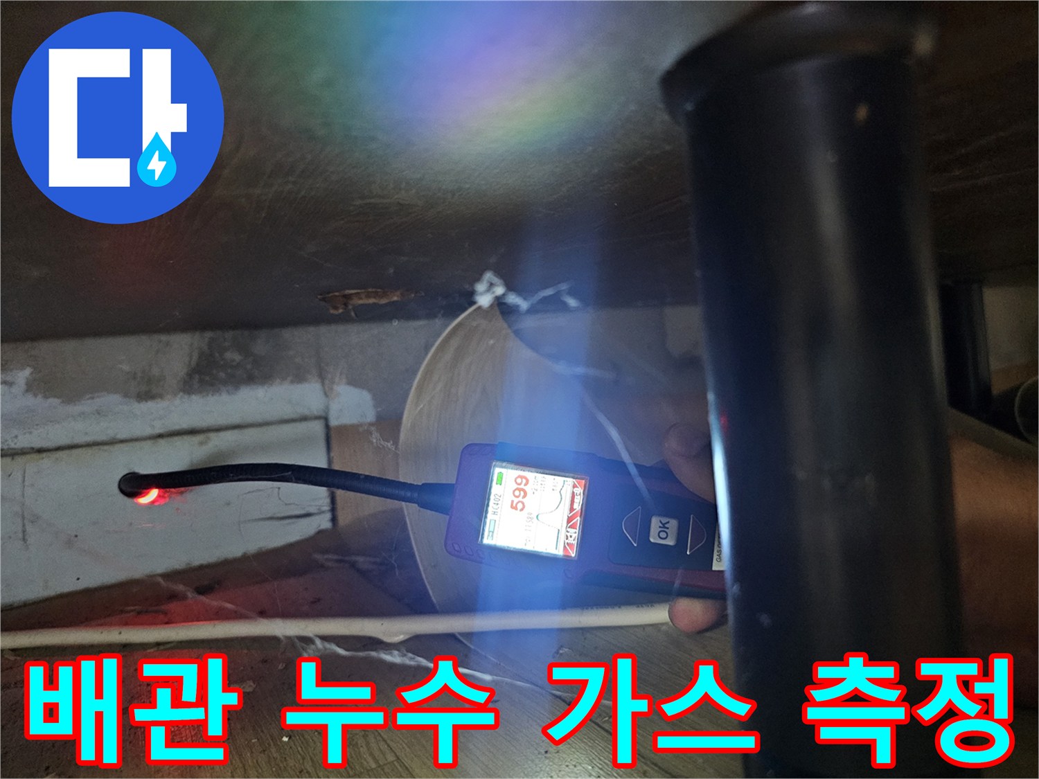 가스 탐지기의 수치를 확인하며 싱크대 아래 배관을 점검하는 장면