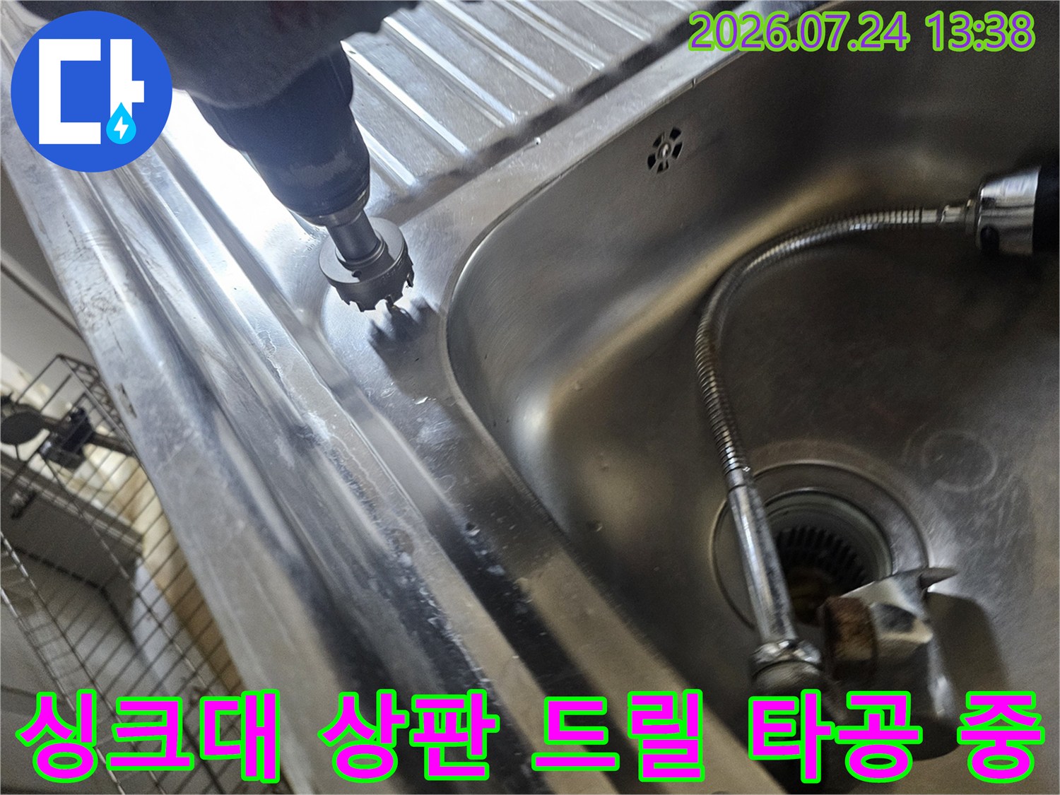 스테인리스 재질의 싱크대 볼 옆면을 전동 공구로 뚫고 있는 장면