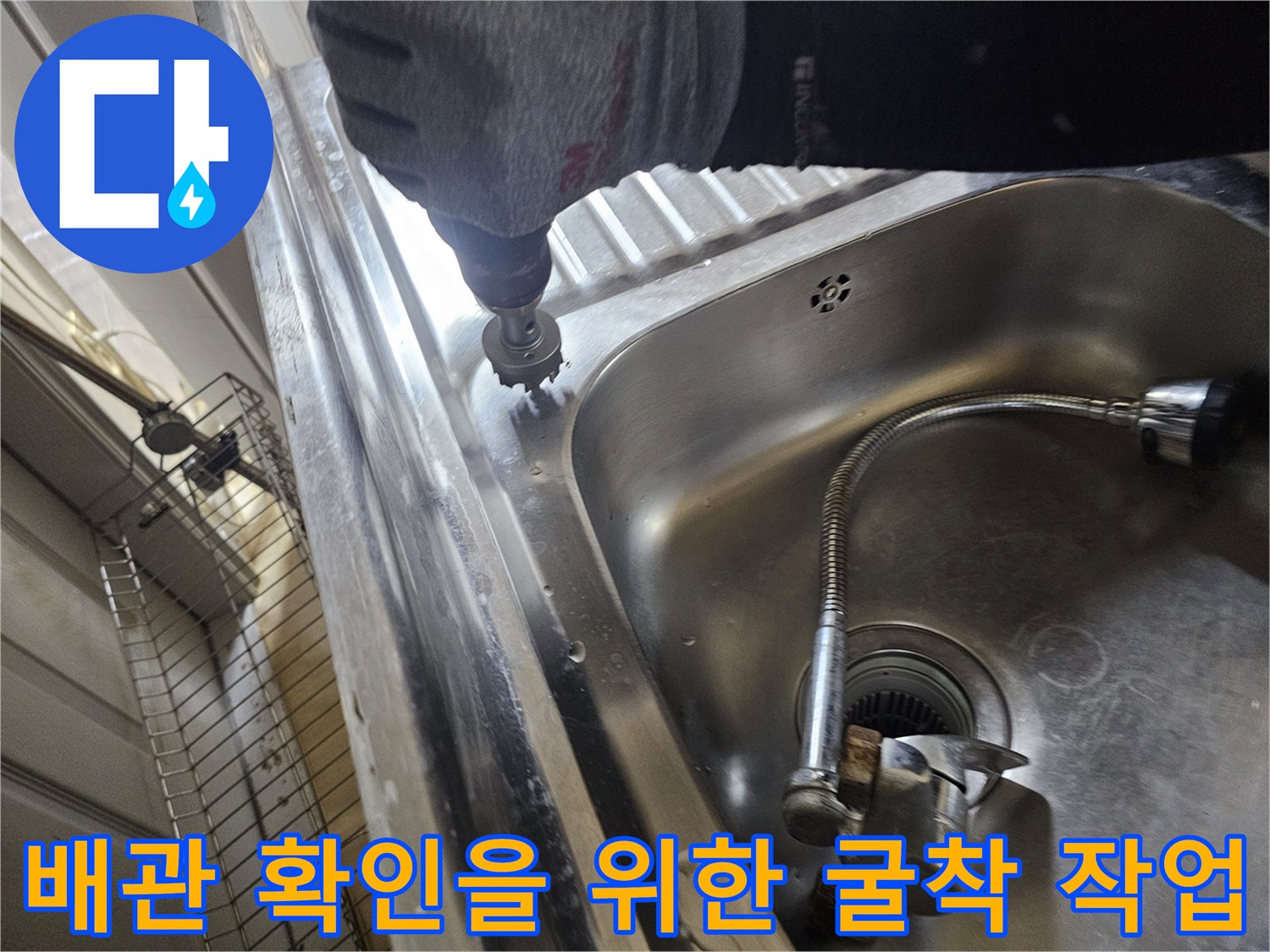 싱크대 수전 근처 바닥을 드릴로 파쇄하며 누수 지점을 찾는 모습