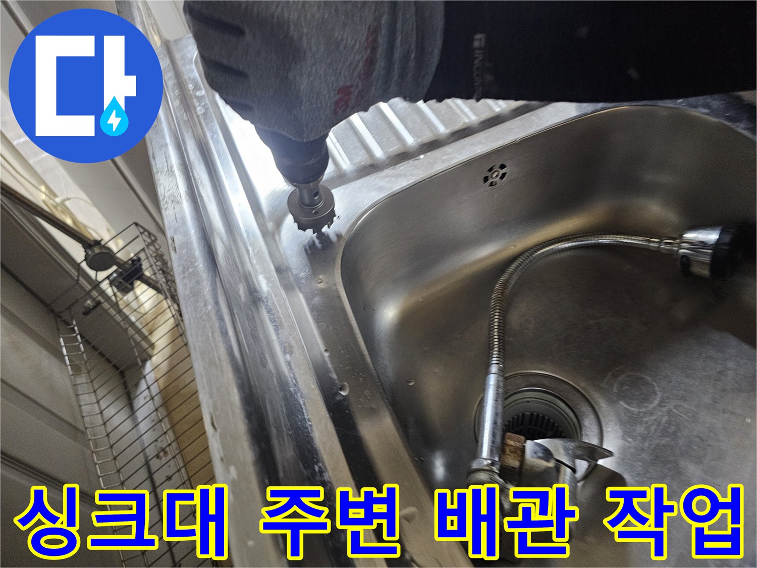 싱크대 스테인리스 볼 근처에서 전동 드릴을 사용하는 배관 점검 모습