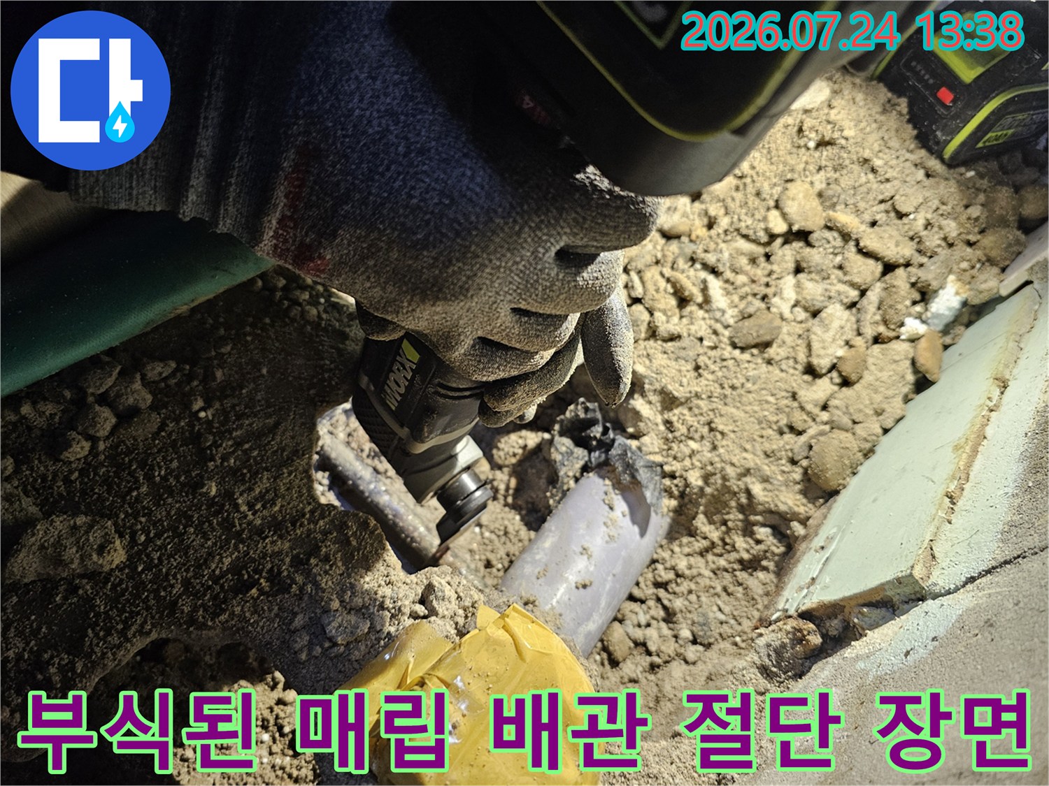 전동 커터를 사용하여-바닥 속 부식된 금속 배관을 잘라내고 있는 작업자의 모습