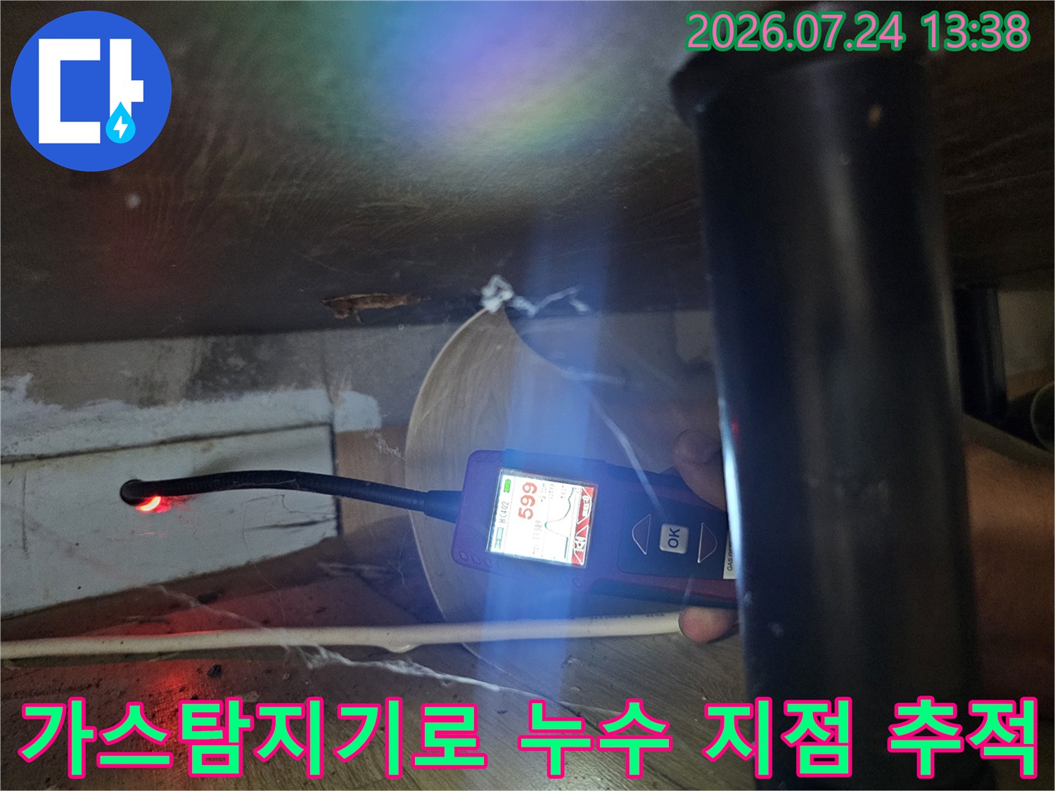 좁은 공간에서 가스 탐지기를 사용해 배관 누수 지점을 찾는 모습