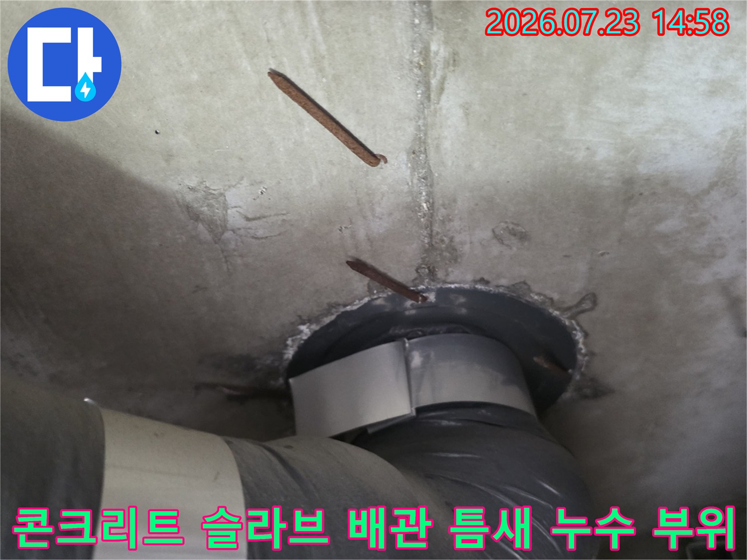 부식된 철근이 노출된 천장 콘크리트 층과 설치된 배관의 연결 모습