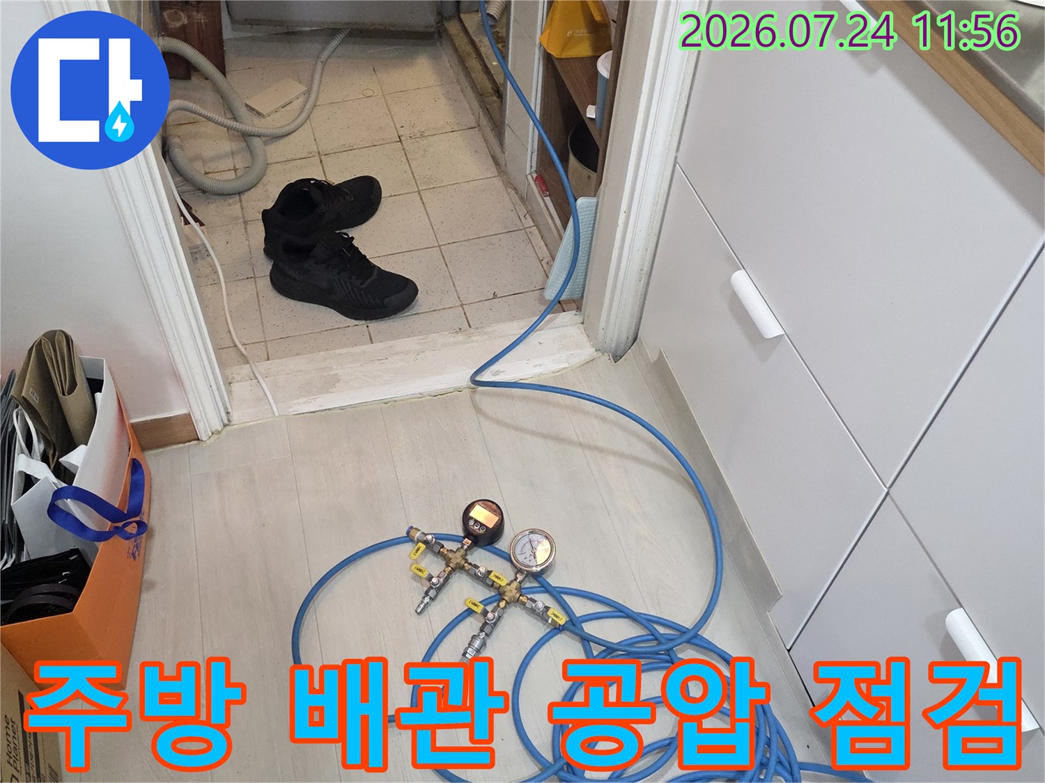 파란색 배관에 연결된 압력계와 호스를 이용해 누수 여부를 정밀하게 점검하는 모습입니다.