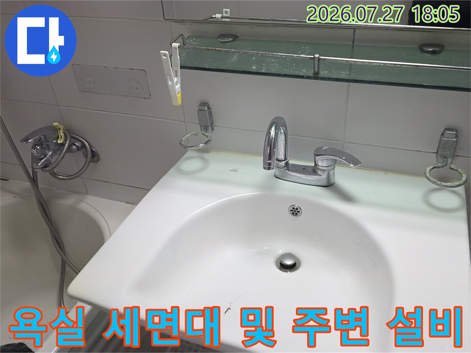 세면대 상판과 거울 선반 그리고 욕조의 일부가 보이는 화장실-내부 전경