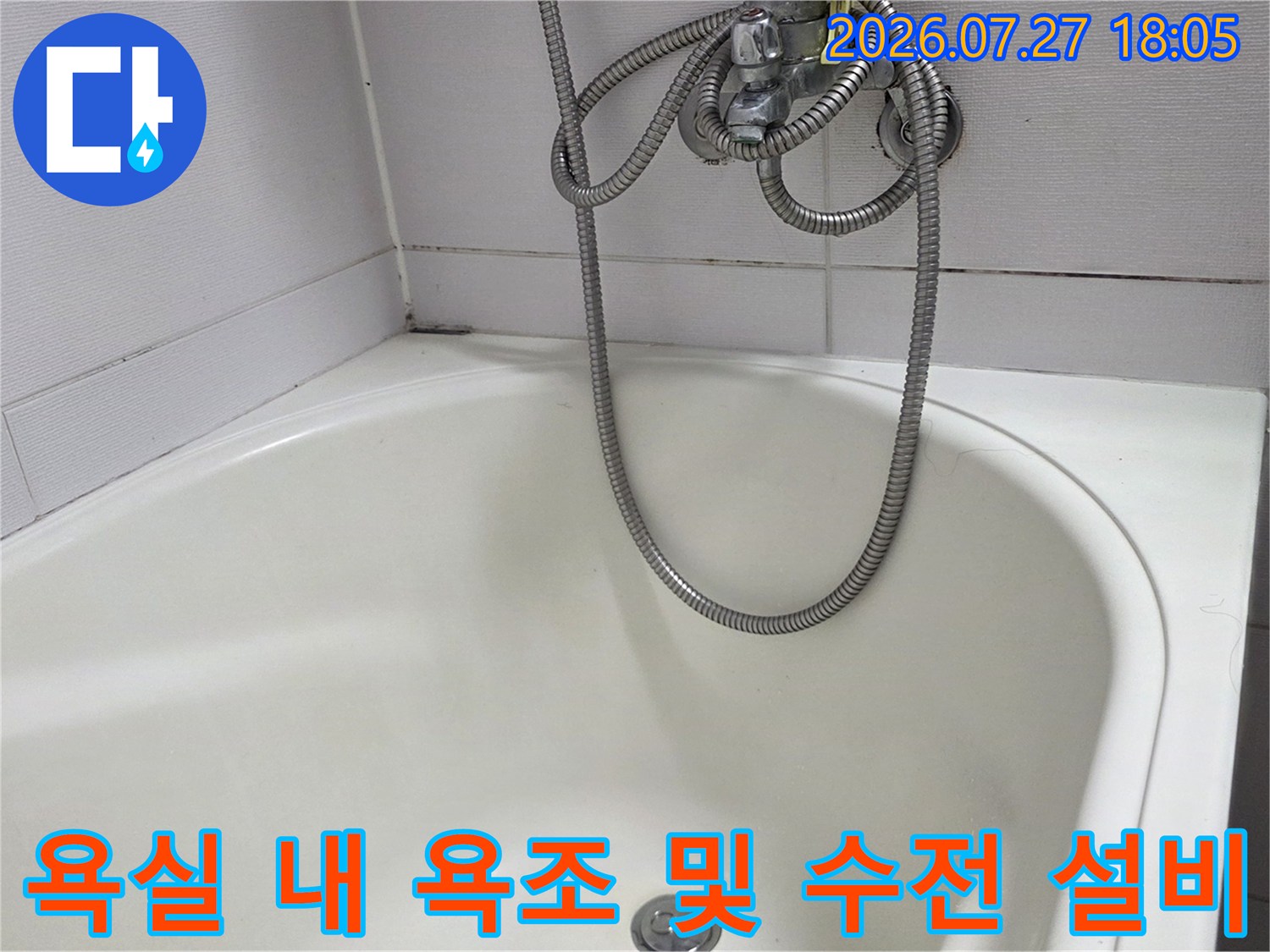 은색 금속 재질의 샤워기 호스가 흰색 욕조 안으로 늘어져 있는 모습