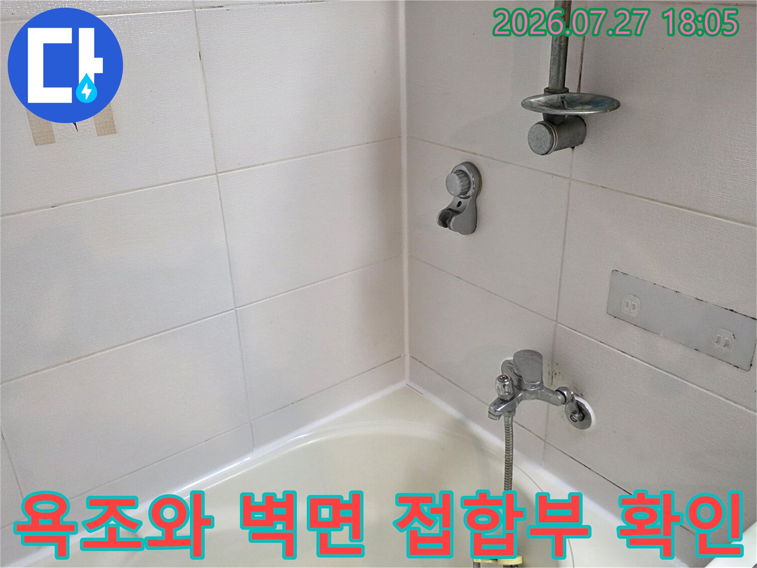 흰색 타일로 마감된 욕실 내부에 설치된 욕조와 수전-벽면 상태를 점검하는 모습