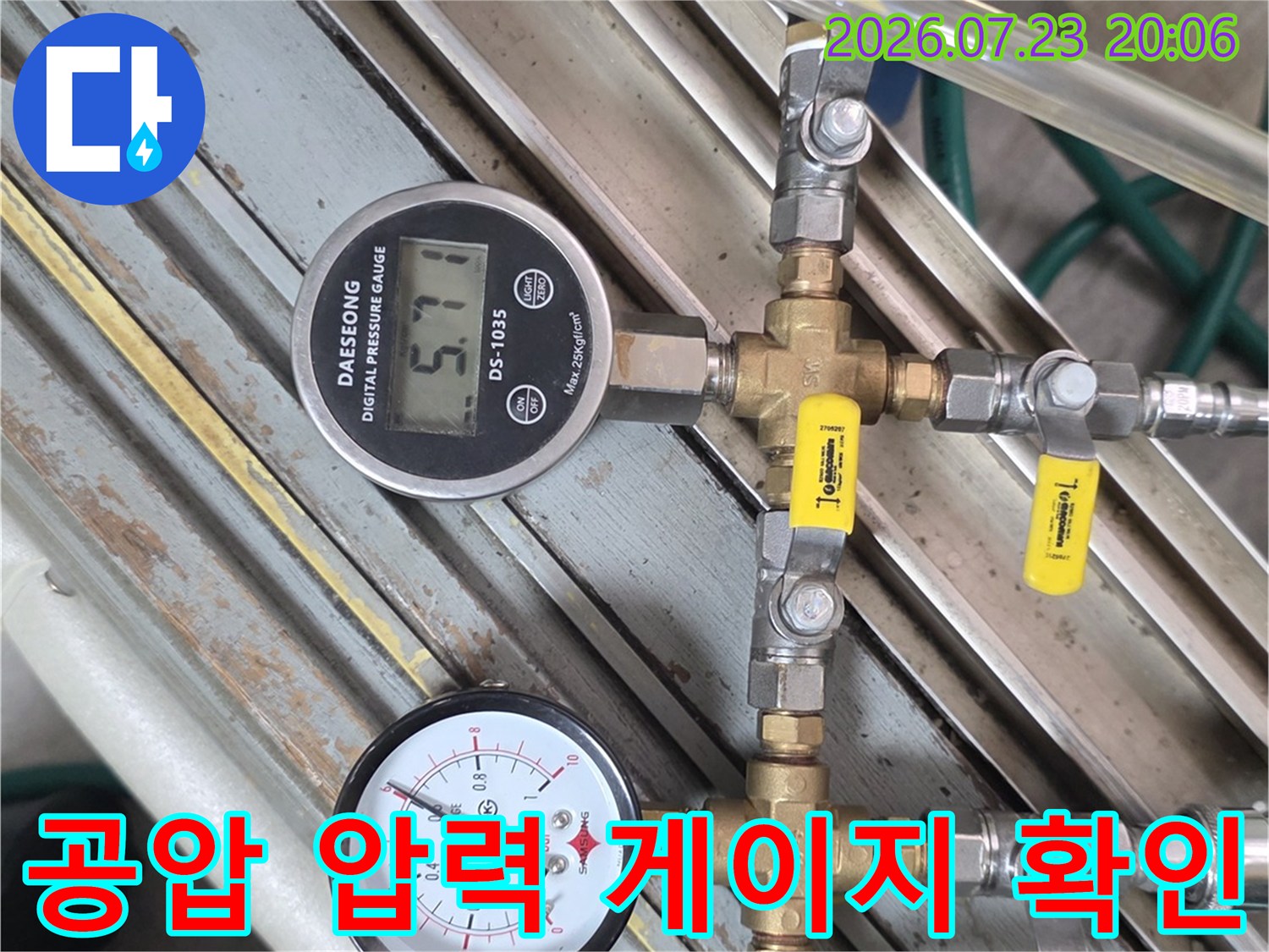배관 시스템에 장착된 두 개의 압력계와 노란색 태그가 붙은 배관 부품