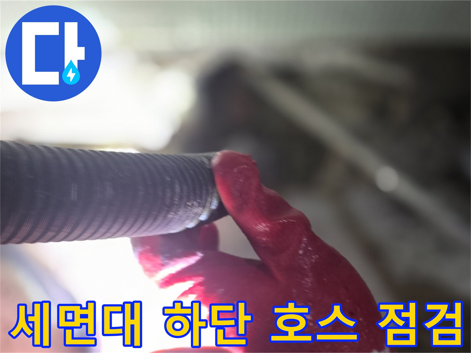 작업자가 붉은 장갑을 착용하고 주름 배관의 연결부를 만지는 사진